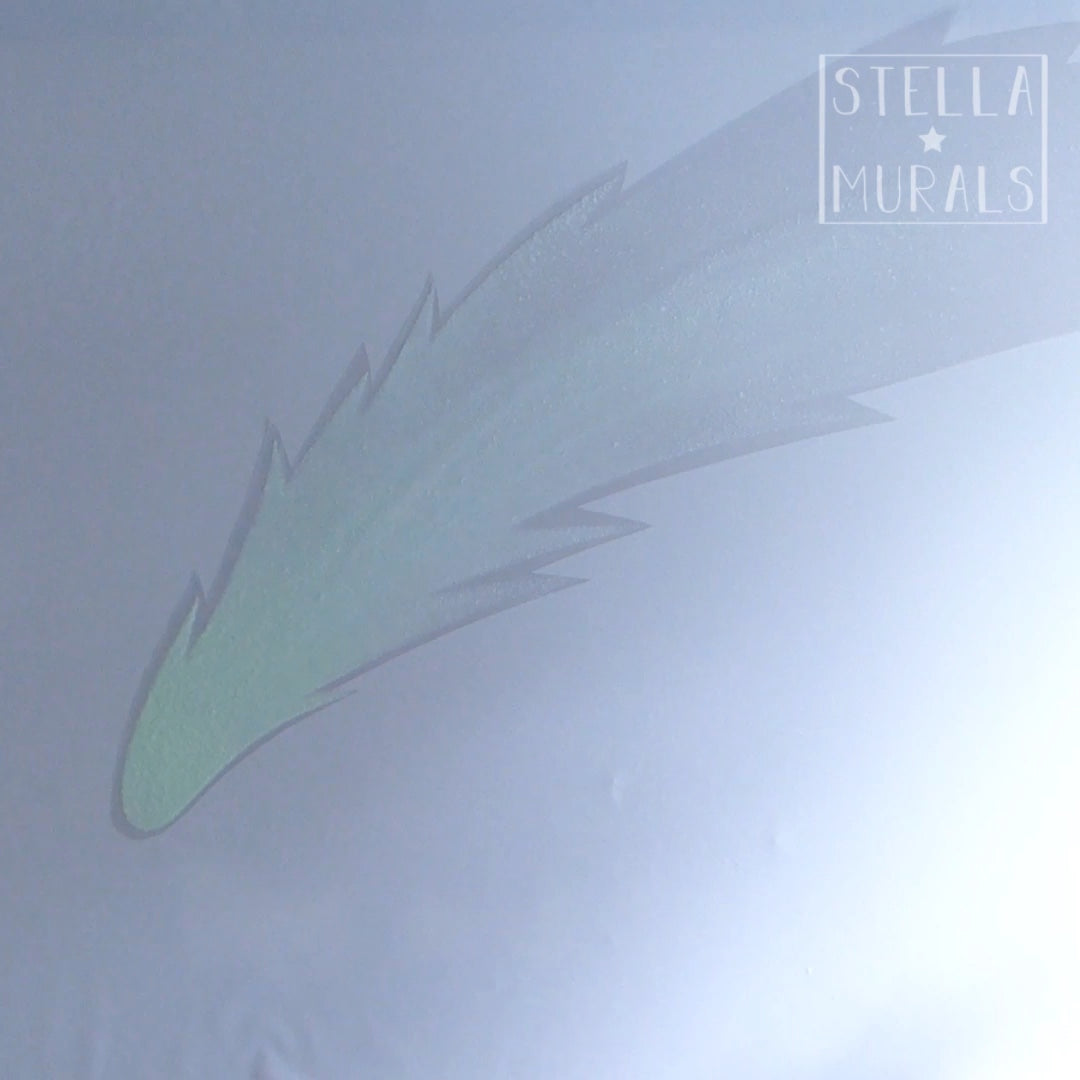 clear glow in the dark decal of comet, installing it onto a wall.