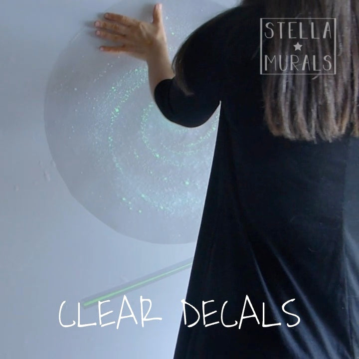 clear glow in the dark spiral galaxy, installing during the day on a smooth bedroom wall.