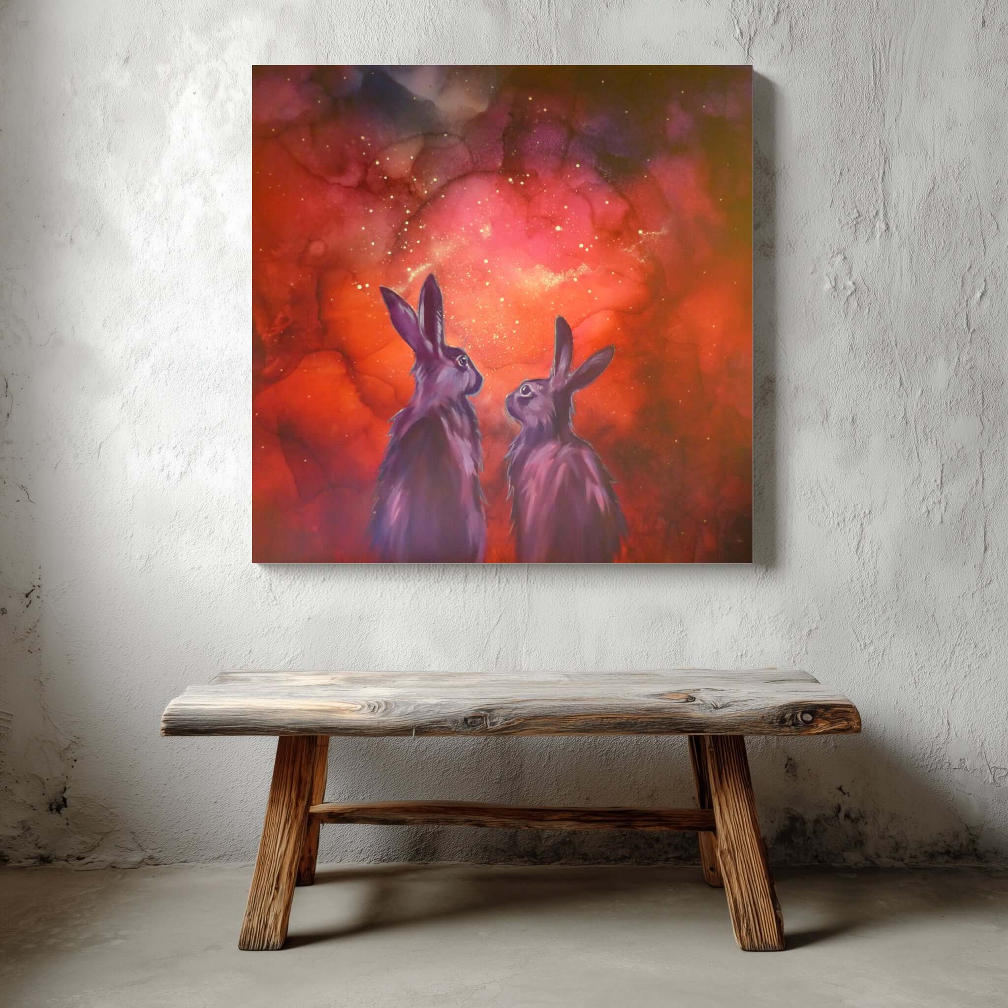 Glow in the dark  painting of two rabbits against a red and orange abstract background, displayed on a textured wall above a wooden bench.