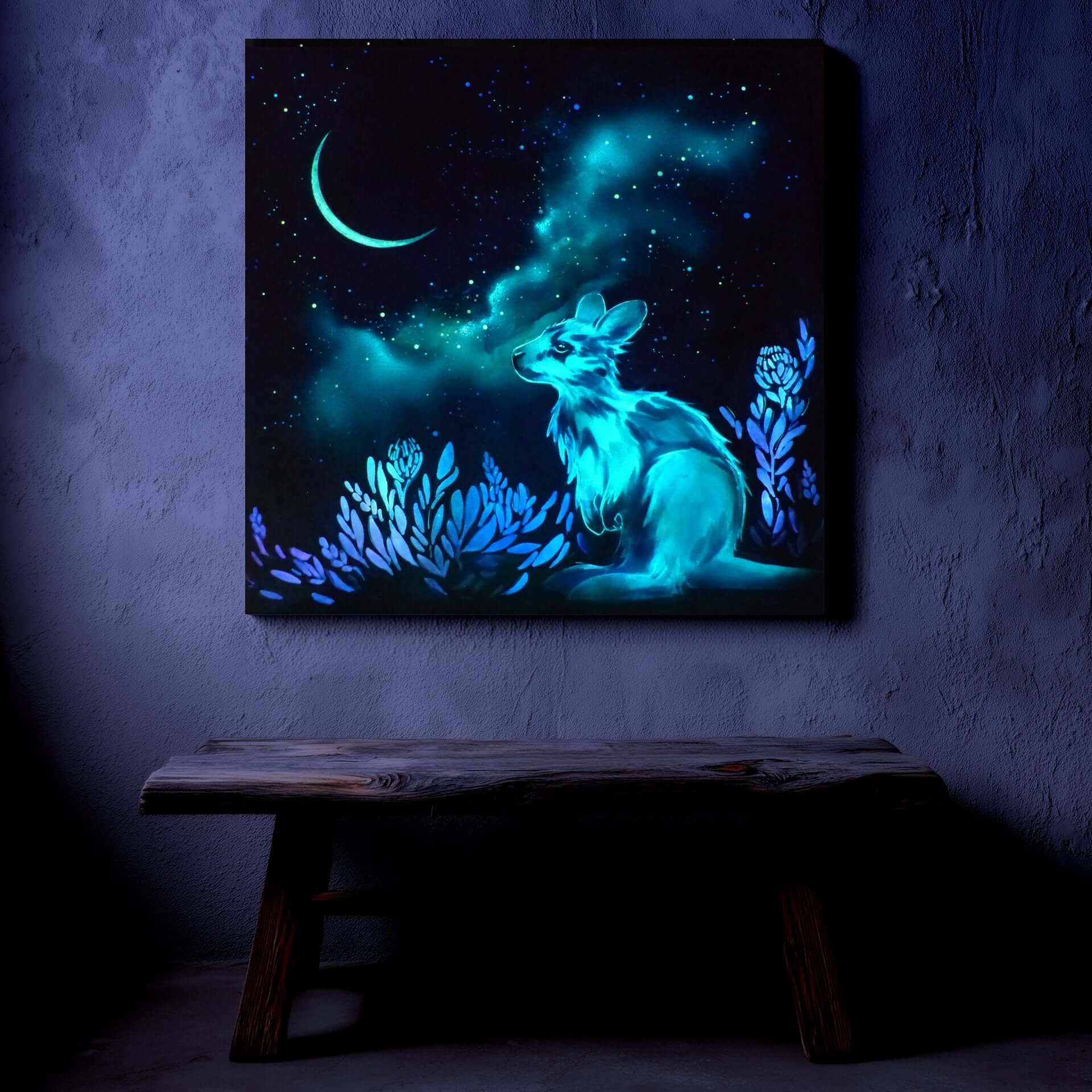 Glowing artwork of a kangaroo with a night sky and moon on a dark wall.