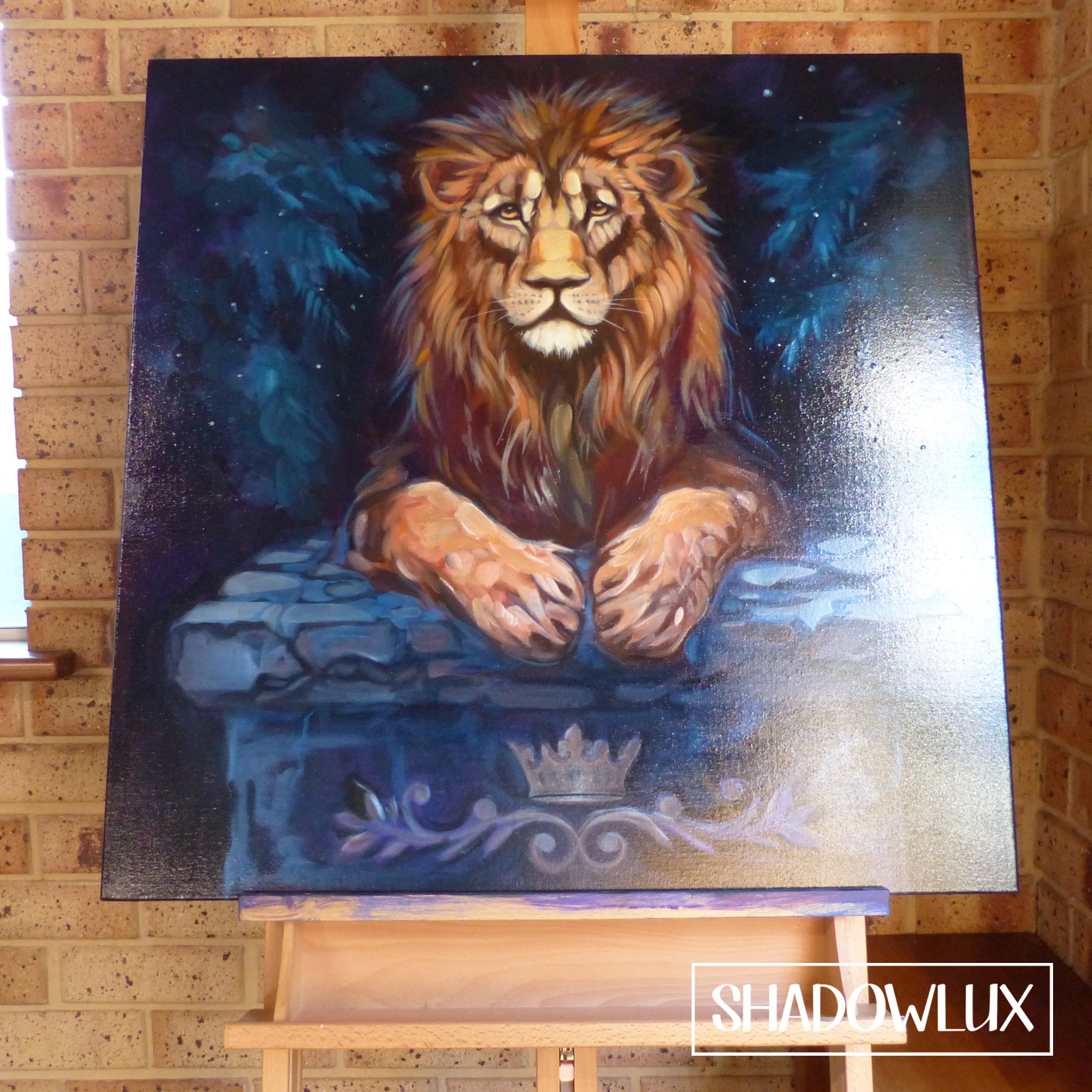 Painting of a lion lying on a stone table in a blue-toned forest during daylight, artwork on an easel