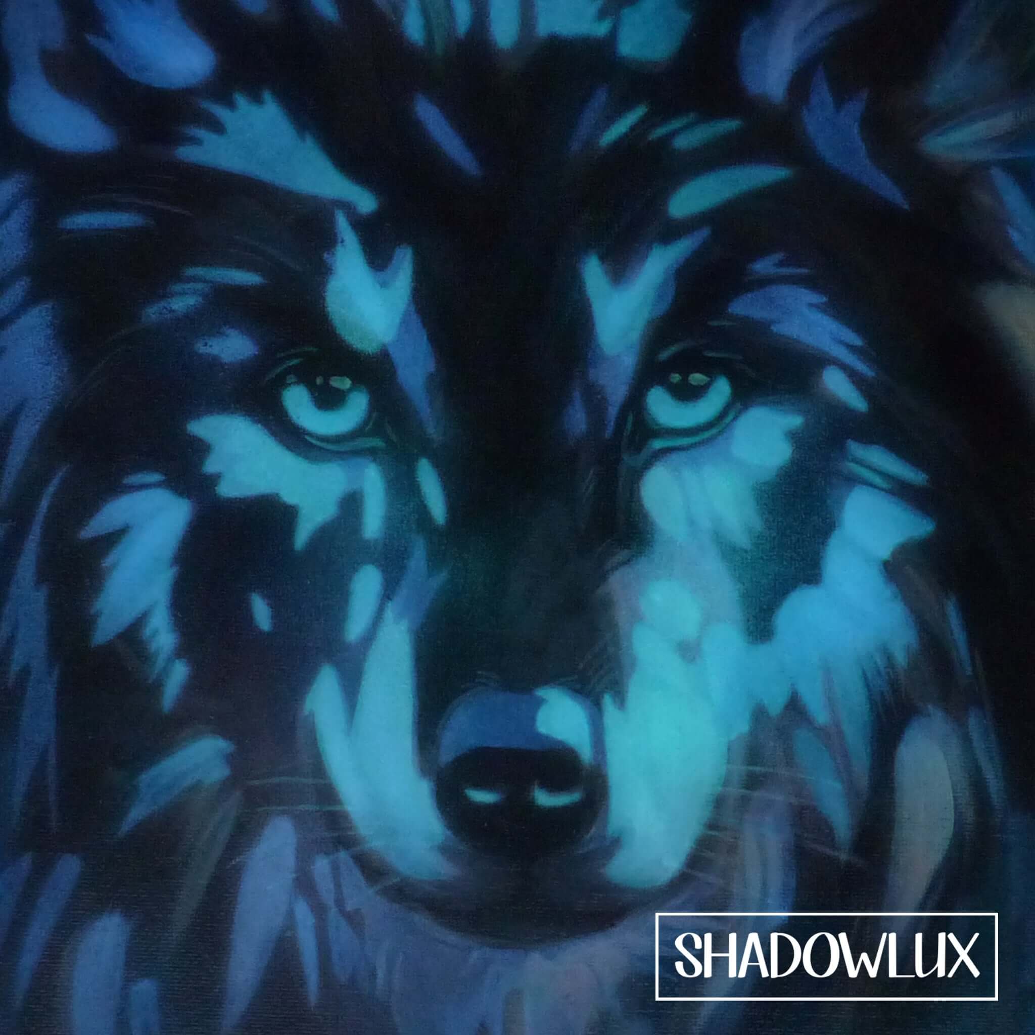 glow in the dark wolf art shown in darkness with glowing blue light emphasizing its features