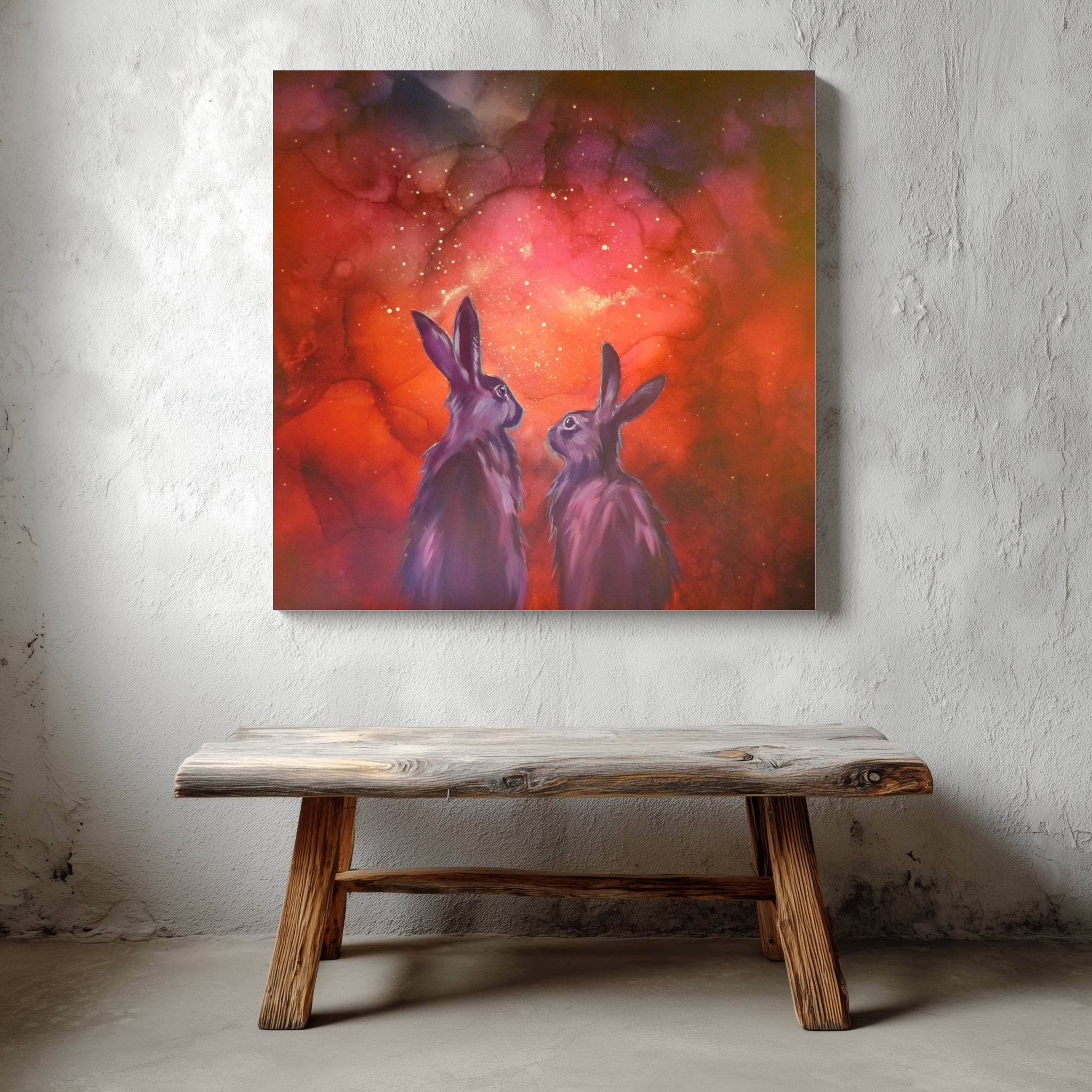 Glow in the dark  painting of two rabbits against a red and orange abstract background, displayed on a textured wall above a wooden bench.