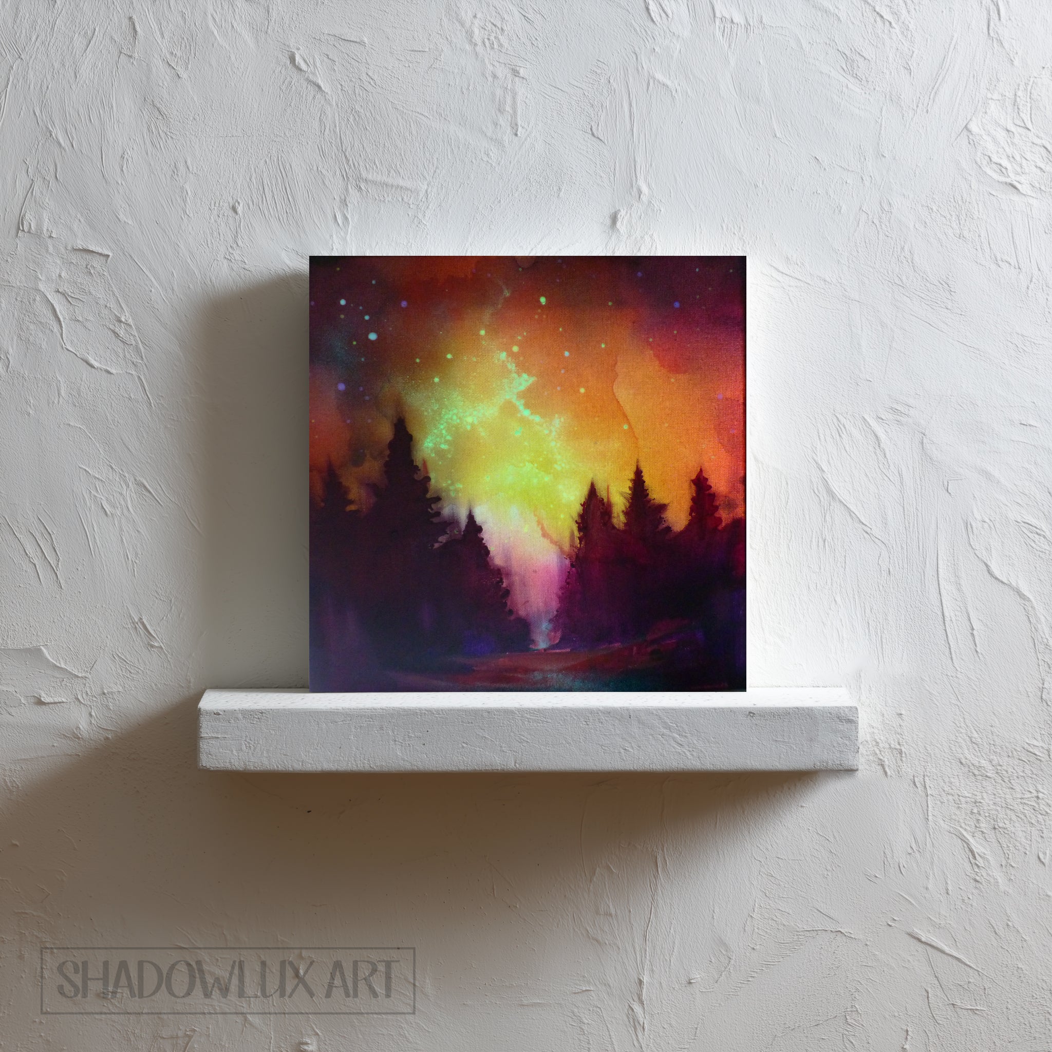 Colorful glow in the dark painting of a forest under a night sky on a white wall.