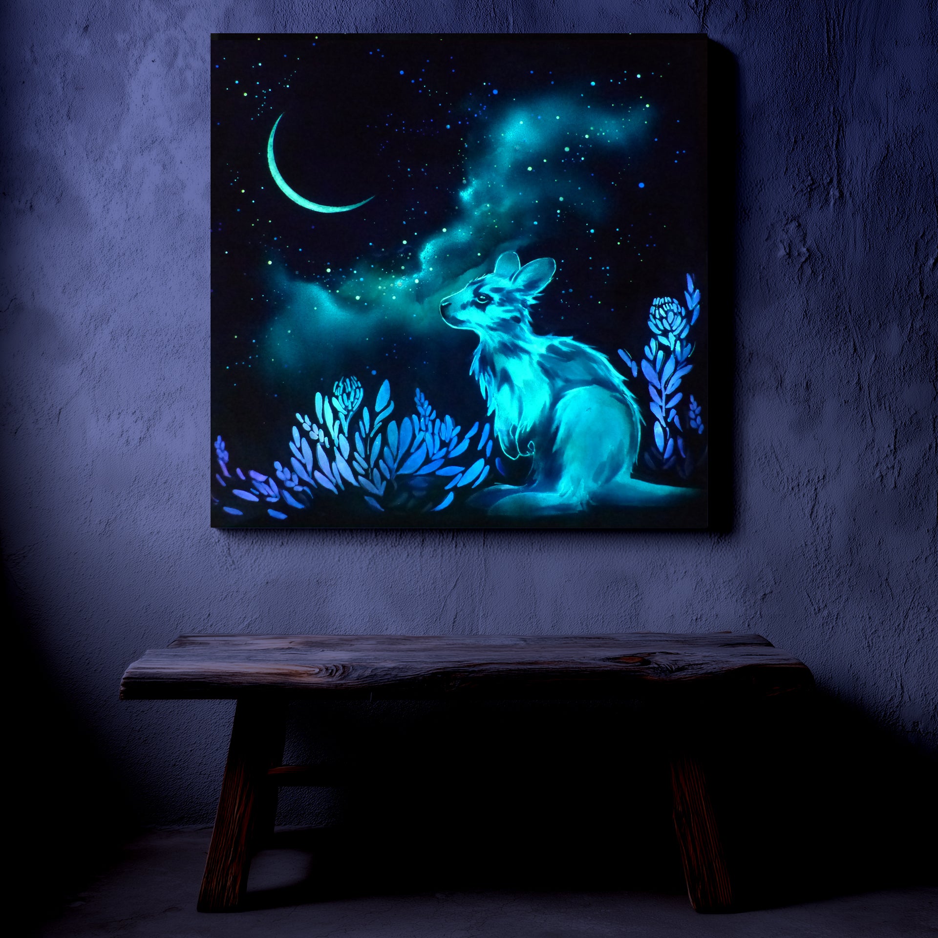 Glowing artwork of a kangaroo with a night sky and moon on a dark wall.