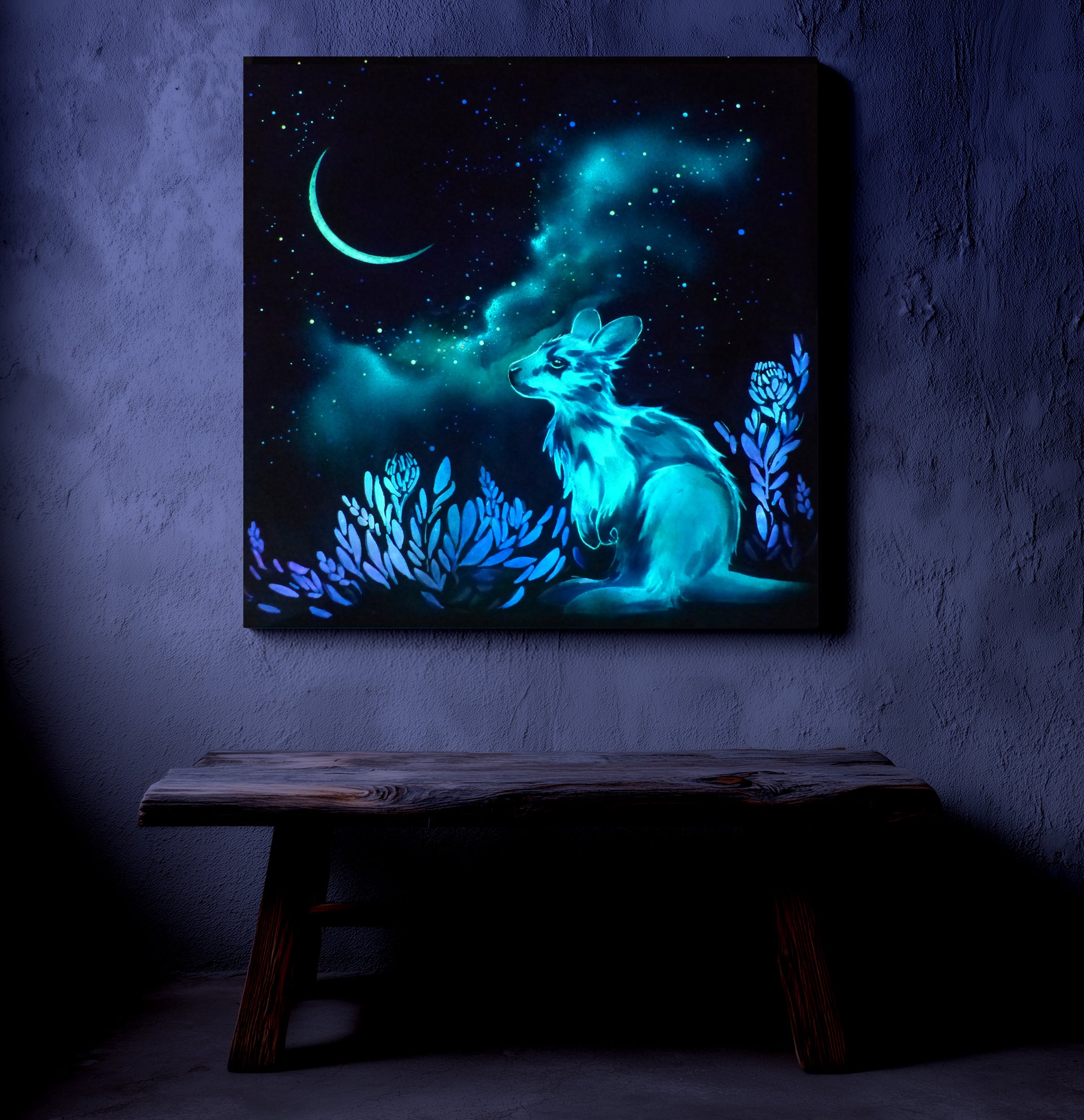 Glowing artwork of a kangaroo with a night sky and moon on a dark wall.