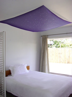 purple or lilac colour glow in the dark fabric, handpainted with stars